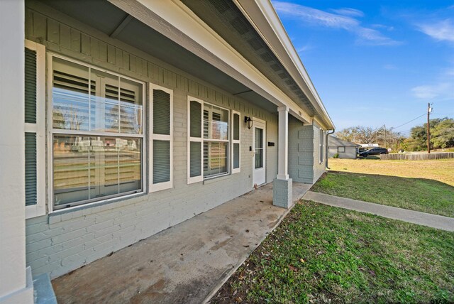 view of exterior entry with a yard