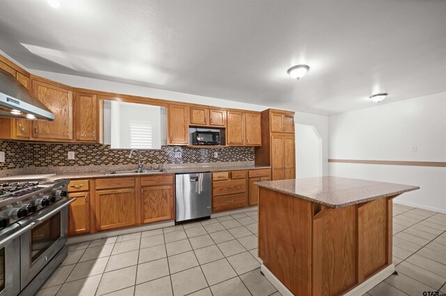 kitchen with sink, light tile patterned flooring, a kitchen bar, a kitchen island, and appliances with stainless steel finishes