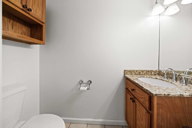 bathroom featuring tile patterned flooring, vanity, and toilet