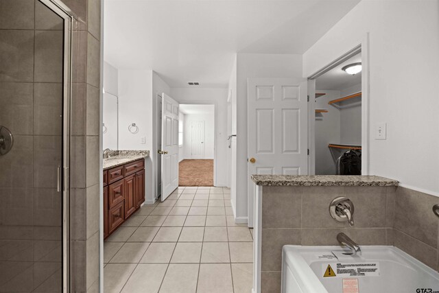 bathroom with tile patterned floors, vanity, and a bathing tub