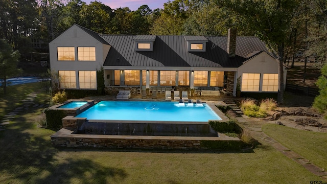 back house at dusk with a yard, a patio, an outdoor hangout area, and a pool with hot tub