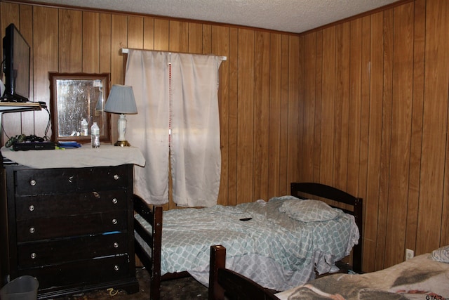 bedroom with wooden walls and a textured ceiling