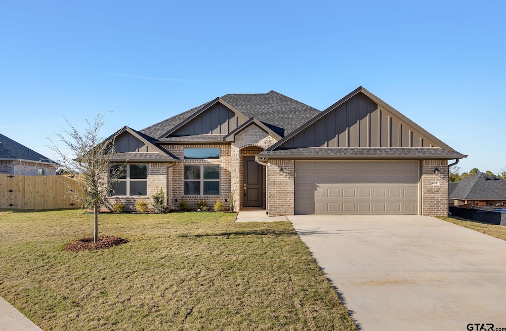 craftsman house featuring a front yard and a garage