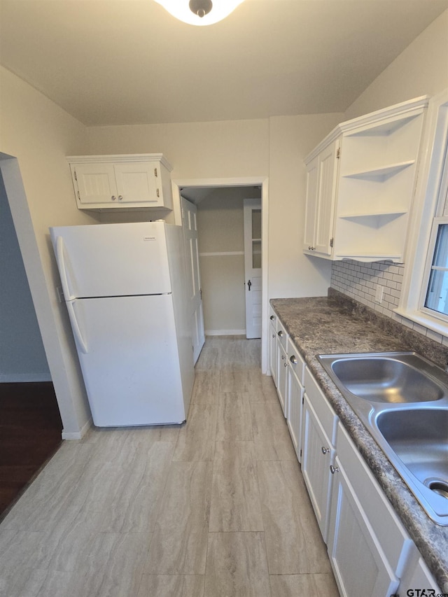 301 Harold St, Crockett, TX 75835 - kitchen with freestanding refrigerator, white cabinetry, open shelves, and light wood-style flooring