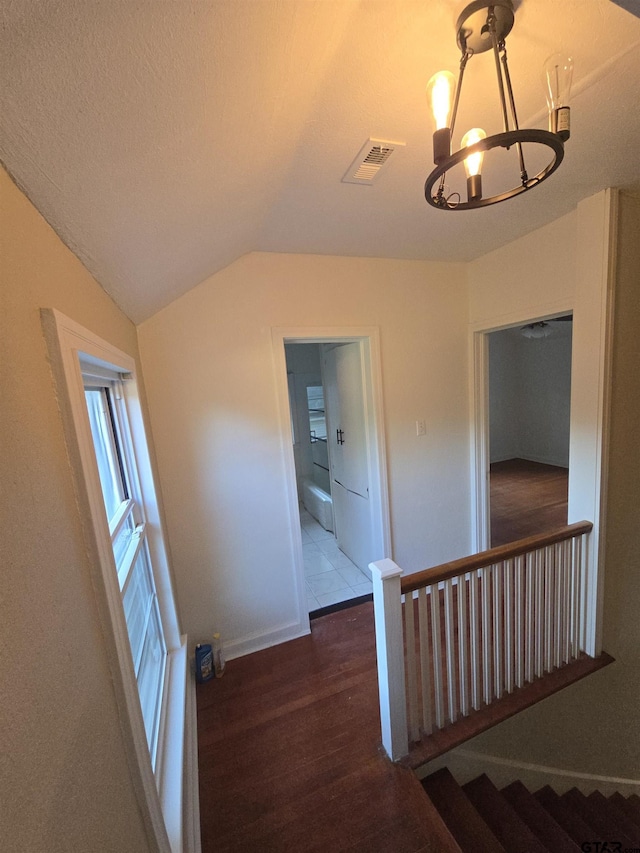 301 Harold St, Crockett, TX 75835 - hallway with wood finished floors, a chandelier, vaulted ceiling, and an upstairs landing