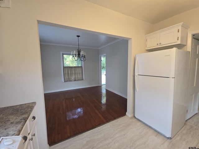 301 Harold St, Crockett, TX 75835 - kitchen with freestanding refrigerator, crown molding, white cabinetry, a chandelier, and light wood-style flooring