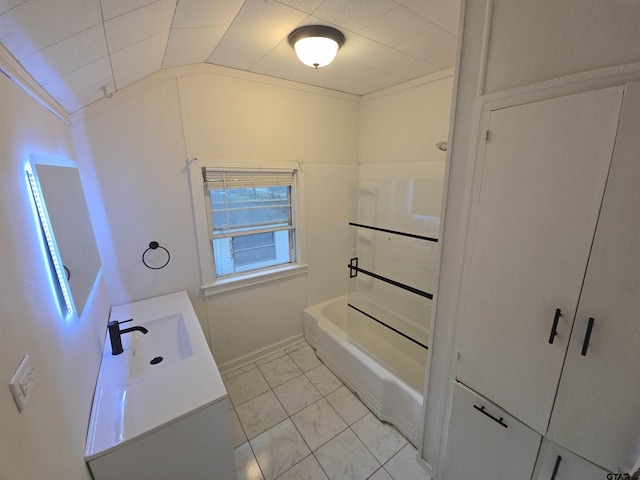 301 Harold St, Crockett, TX 75835 - full bathroom featuring marble look tiles, lofted ceiling, vanity, and shower / washtub combination