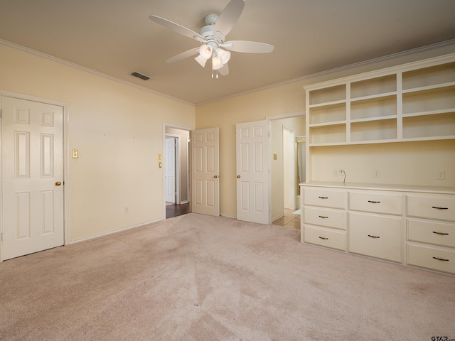 unfurnished bedroom featuring ceiling fan, crown molding, and light carpet