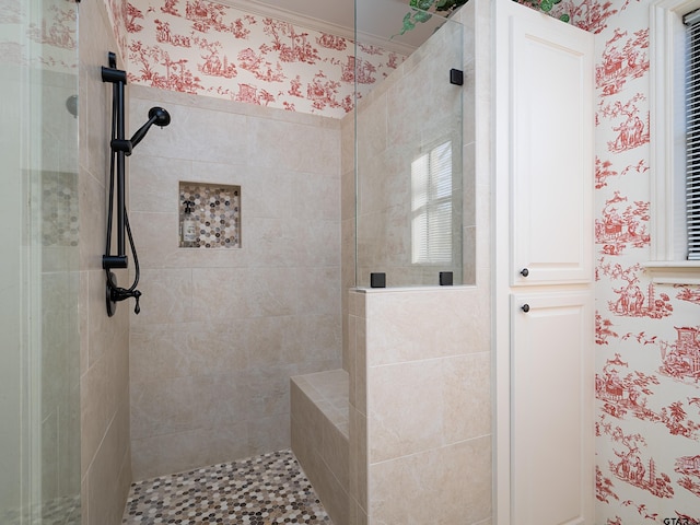 bathroom with crown molding and tiled shower