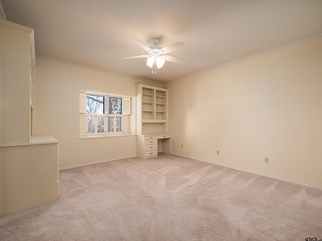 carpeted spare room with ceiling fan and crown molding