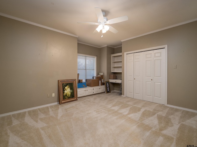 unfurnished bedroom featuring ceiling fan, crown molding, a closet, and light carpet