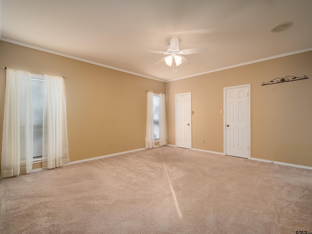 carpeted spare room featuring ornamental molding and ceiling fan