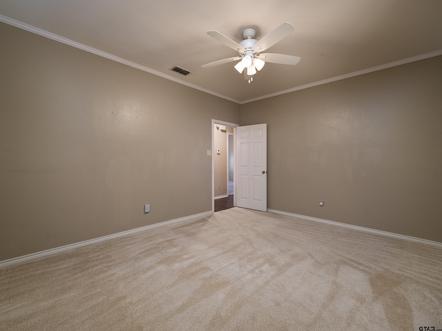 carpeted spare room with ceiling fan and crown molding