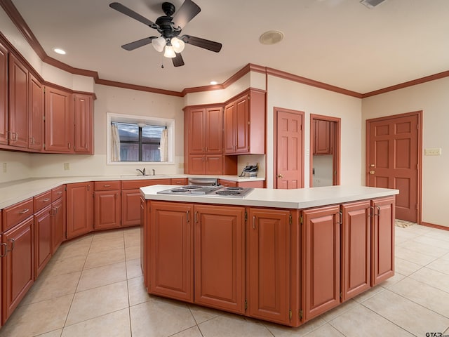 kitchen featuring a center island, stainless steel gas stovetop, light tile patterned floors, and ornamental molding