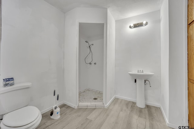 full bathroom featuring a shower stall, toilet, baseboards, and wood finished floors