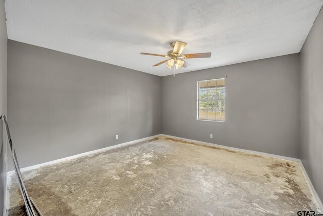 empty room with baseboards, a textured ceiling, and a ceiling fan