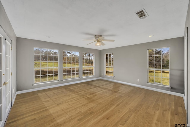 unfurnished sunroom with visible vents and ceiling fan