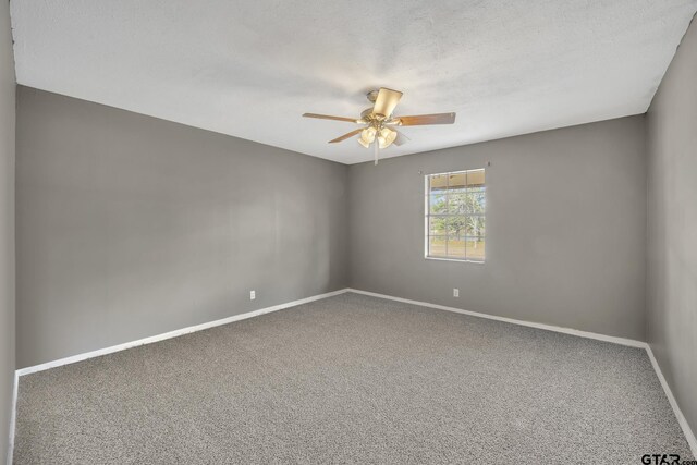 unfurnished room featuring a ceiling fan, baseboards, carpet floors, and a textured ceiling