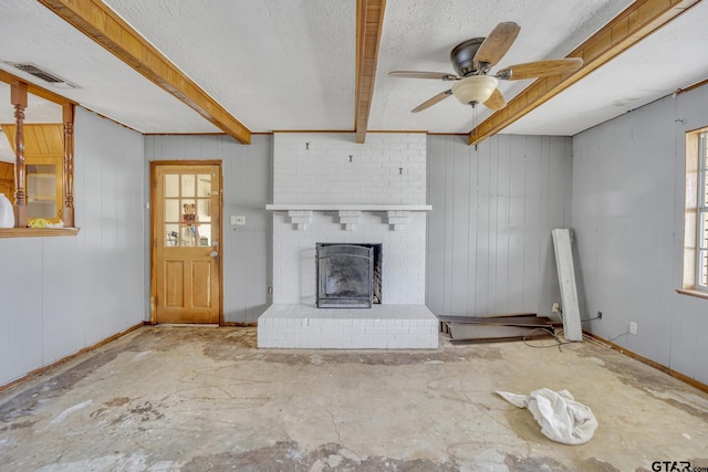 unfurnished living room featuring visible vents, a brick fireplace, baseboards, beamed ceiling, and a textured ceiling