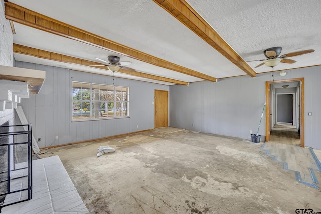 unfurnished living room featuring beamed ceiling, a textured ceiling, and a ceiling fan