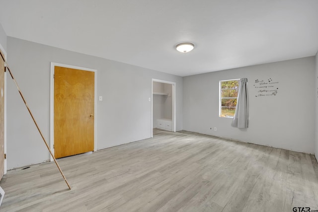 unfurnished bedroom featuring a closet and light wood-style floors