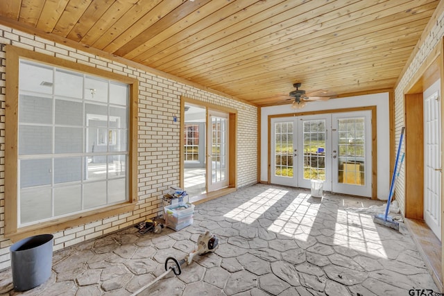 unfurnished sunroom with wood ceiling and a ceiling fan