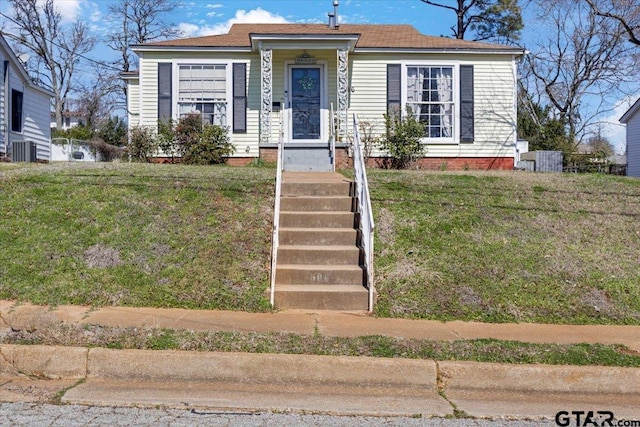 bungalow-style home with central AC and a front lawn