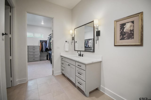 7863 Cross Rd, Tyler, TX 75703 - bathroom featuring vanity, a walk in closet, baseboards, and tile patterned floors