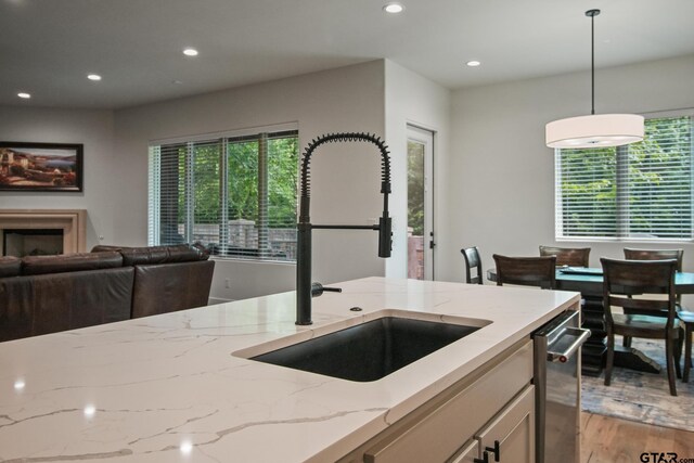 7863 Cross Rd, Tyler, TX 75703 - kitchen with light stone counters, a sink, recessed lighting, decorative light fixtures, and open floor plan