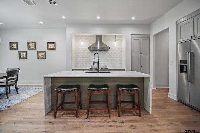 7863 Cross Rd, Tyler, TX 75703 - kitchen with high end fridge, gray cabinetry, an island with sink, a kitchen bar, and recessed lighting