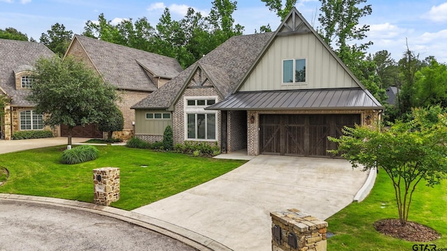 7863 Cross Rd, Tyler, TX 75703 - view of front of property featuring board and batten siding, driveway, a standing seam roof, brick siding, and a front yard