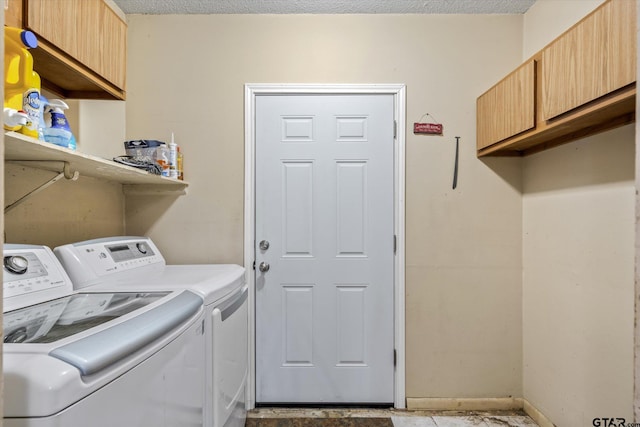 laundry room with washer and clothes dryer, cabinets, and a textured ceiling