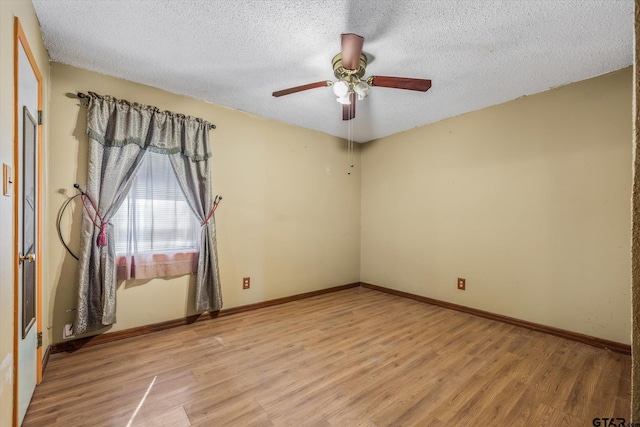 empty room with a textured ceiling, ceiling fan, and light hardwood / wood-style flooring