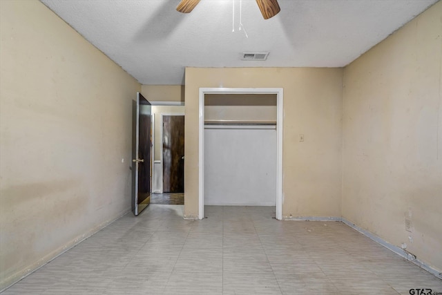 unfurnished bedroom with a closet, a textured ceiling, and ceiling fan