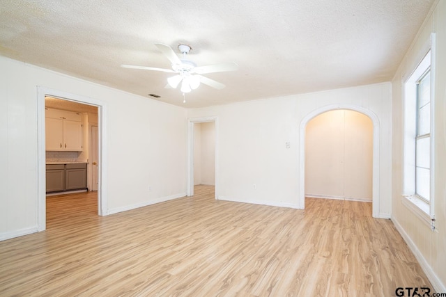 unfurnished room featuring a textured ceiling, light hardwood / wood-style floors, and ceiling fan