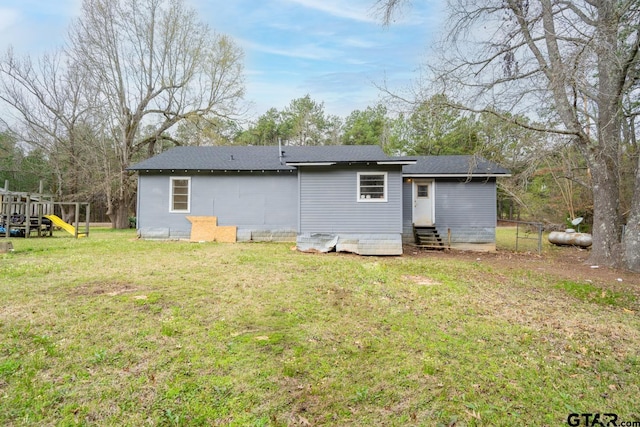 rear view of house featuring a yard and a playground