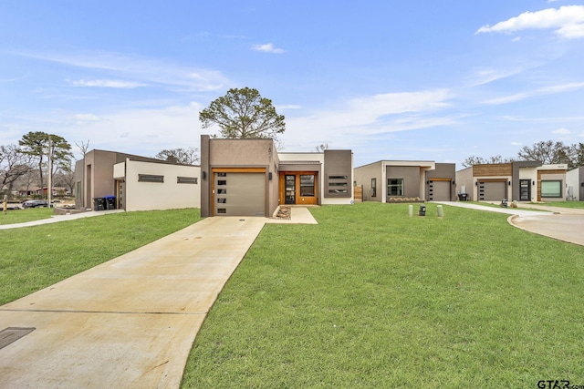 view of front of home featuring stucco siding, a front lawn, an attached garage, and driveway