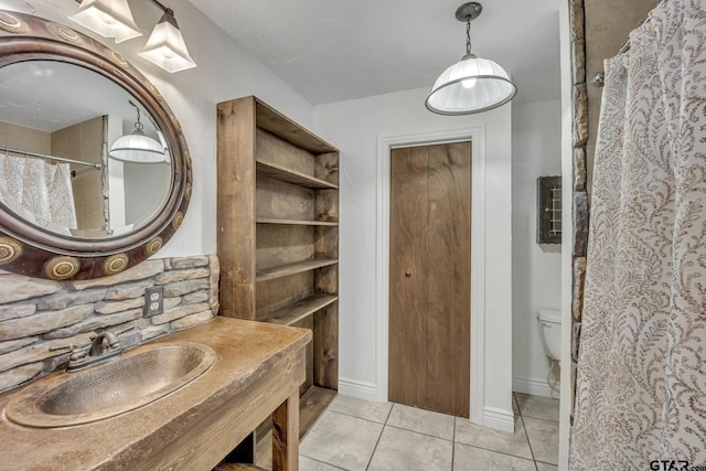 2010 County Road 4250, Winnsboro, TX 75494 - full bathroom featuring a sink, tile patterned flooring, toilet, and baseboards
