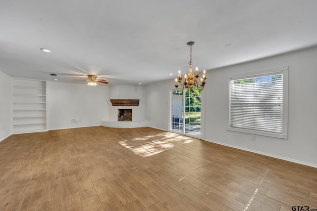 2010 County Road 4250, Winnsboro, TX 75494 - unfurnished living room with a fireplace, a ceiling fan, a chandelier, light wood finished floors, and built in shelves