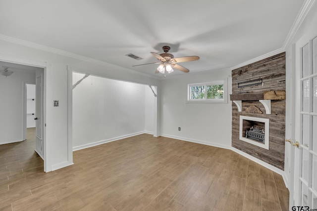 2010 County Road 4250, Winnsboro, TX 75494 - unfurnished living room with ceiling fan, a stone fireplace, light wood-type flooring, baseboards, and crown molding