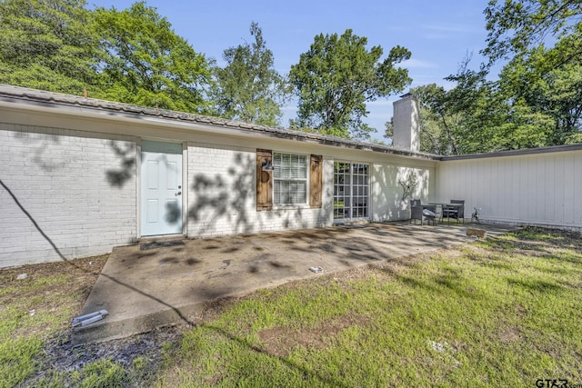2010 County Road 4250, Winnsboro, TX 75494 - back of property featuring brick siding, a patio area, a chimney, and a yard