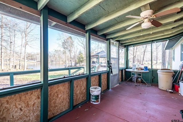 unfurnished sunroom featuring ceiling fan and a water view