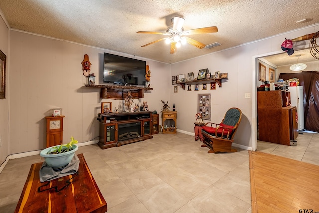 living room featuring ceiling fan and a textured ceiling