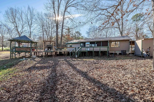 back of property featuring a wooden deck, a gazebo, and cooling unit