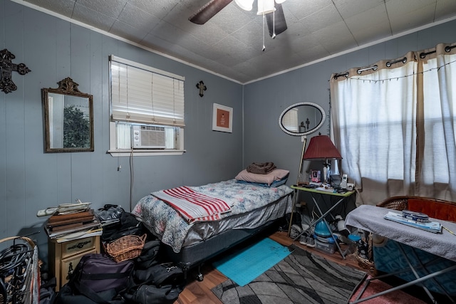 bedroom featuring crown molding, wood-type flooring, cooling unit, and ceiling fan