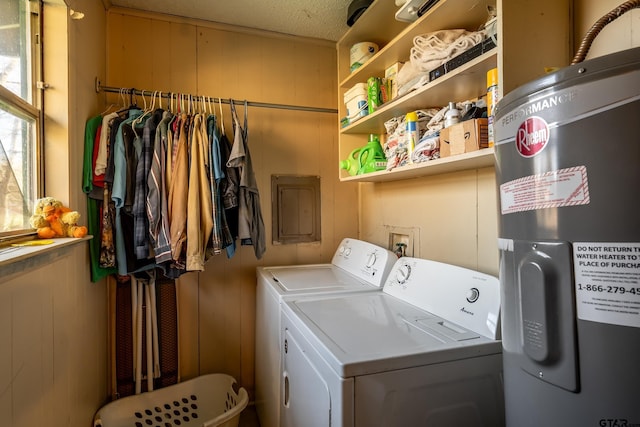 laundry area with wood walls, water heater, and washer and dryer