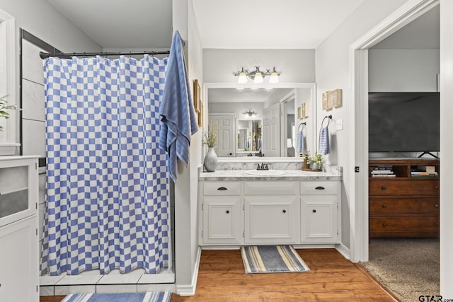 5513 Bostick Dr, Tyler, TX 75707 - bathroom featuring a shower with shower curtain, vanity, and wood finished floors