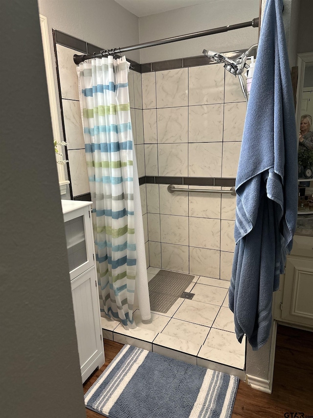 bathroom featuring a shower stall and wood finished floors