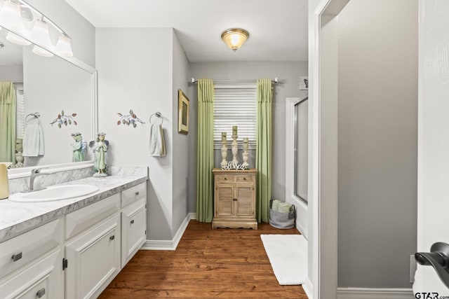 5513 Bostick Dr, Tyler, TX 75707 - full bathroom with vanity, wood finished floors, and baseboards