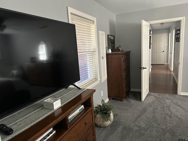 bedroom with dark carpet and baseboards